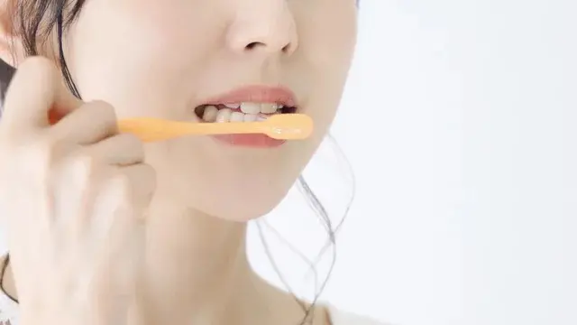 女性が歯を磨いている画像